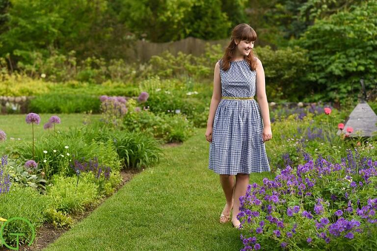 A high school senior walks through the gardens during her senior session at Matthaei Botanical Gardens