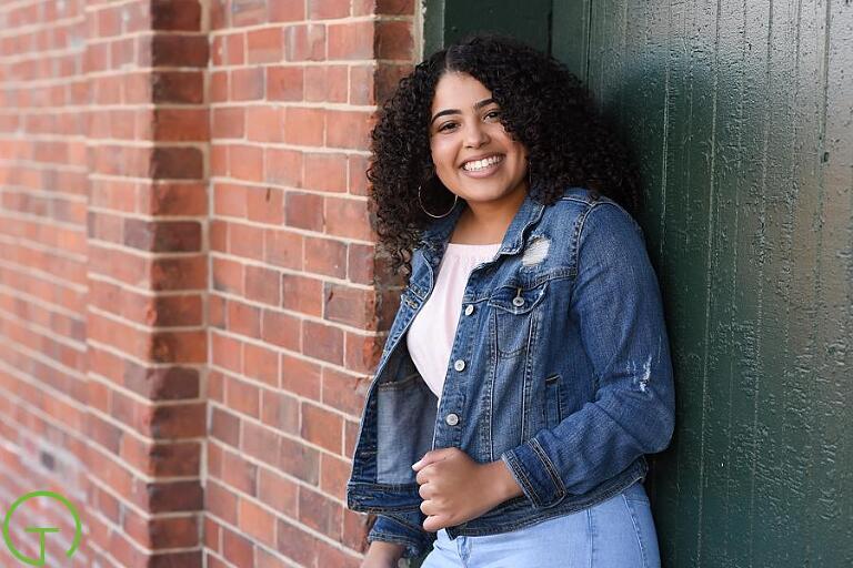 A high school senior poses near Ypsilanti's freighthouse for her senior portrait