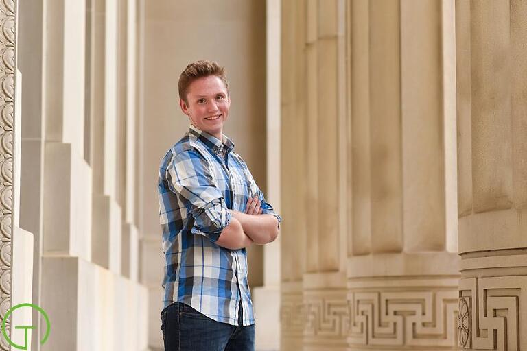 A high school senior poses near the beautiful columns of Angell Hall in Downtown Ann Arbor for his portrait
