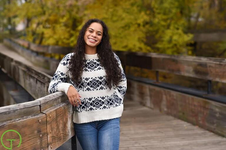 A high school senior poses on a bridge in Ypsilanti’s depot town during her Ypsilanti senior portrait session